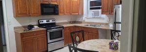 a kitchen with wooden cabinets and a stove top oven at PalmBeachHousefrom69DaylyforPrsmin2PersPPartyP3rRoom in West Palm Beach
