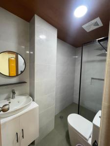 a bathroom with a sink and a toilet and a mirror at Constrell Pension House in Tagbilaran City