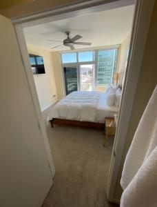 Schlafzimmer mit einem Bett, einem Deckenventilator und einem Fenster in der Unterkunft Skyline & Ocean Views I Faith Filled SF Stay Gym in San Francisco + 33 Fotos