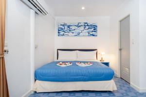 a bedroom with a blue bed with two pillows at Oceanview Bungalows by EAT, Karon Beach in Karon Beach