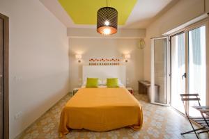 a bedroom with a large yellow bed with green pillows at Il Quadrato Bed and Breakfast in Marina di Schiavonea