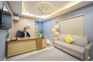 a woman sitting at a desk in a waiting room at Hotel Urban Stayz, HITEC City, Hyderabad in Hyderabad