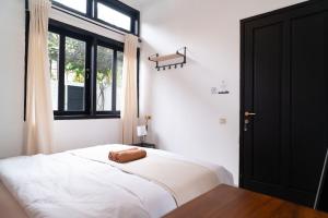 une chambre avec un lit blanc avec une fenêtre dans l'établissement Casuarina Villa - City Center American Classic Villa, à Bandung