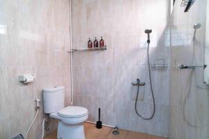 La salle de bains est pourvue d'une douche, de toilettes et d'une douche en verre. dans l'établissement Casuarina Villa - City Center American Classic Villa, à Bandung