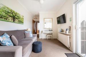 a living room with a couch and a table at Garden of the Stars - Studio - Breathtaking View, Echo Point in Katoomba