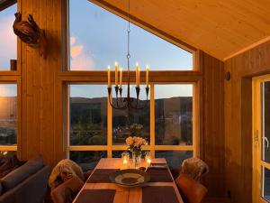 a dining room with a table and a large window at Modern Cabin With Views By Ski Trail In Hadeland in Roa