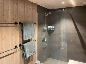 a bathroom with a shower with a glass door at Modern Cabin With Views By Ski Trail In Hadeland in Roa +25 photos