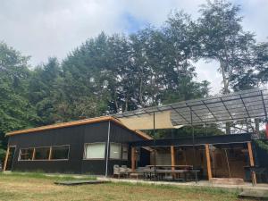 a black house with a solar roof and a table at Gate House Santuario in Valdivia