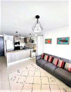 a living room with a couch and a kitchen at Cómodo departamento céntrico in Arica +8 photos