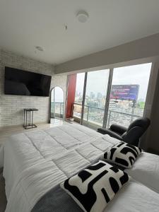 Un dormitorio con una cama grande y una ventana grande en Acogedor Loft con ubicación céntrica en Lima, en San Antonio