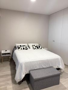 1 dormitorio con cama blanca grande y taburete en Acogedor Loft con ubicación céntrica en Lima, en San Antonio