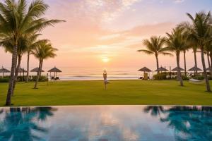 a woman practices yoga by the ocean at the resort at Hoi An Royal Beachfront Resort & Villas in Dien Ban +145 photos