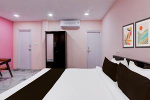 a bedroom with a white bed and pink walls at Hotel O Ss ome inn ultra luxury rooms in Ameerpet +25 photos