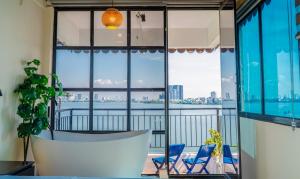 a balcony with blue chairs and a large window at An Homestay Lakeview Apartment in Hanoi +82 photos