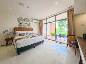 a bedroom with a large bed and a balcony at Patra Semarang Hotel & Convention in Semarang +13 photos