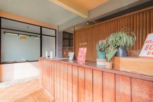 a restaurant with a counter with plants on it at RedDoorz at Palagan Joglo Sersan Bajuri in Bandung