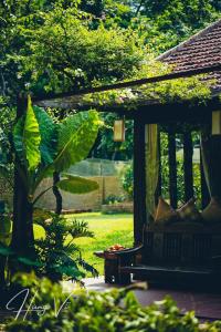 a porch with a bench in a garden at Đến Nơi Có Gió - Homestay And Coffee in Hữu Lũng