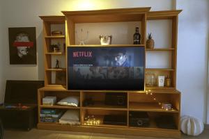 ein Fernseher, der auf einem Entertainment-Center mit einem Fernseher sitzt in der Unterkunft Bed & Coffee in Néa Péramos