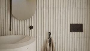 a bathroom with a sink and a mirror on a wall at Escape to Summer, Bilgola Plateau IH Luxe in Bilgola +6 photos