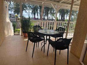 a patio with a table and chairs on a porch at Beachfront Habitat in Flic-en-Flac