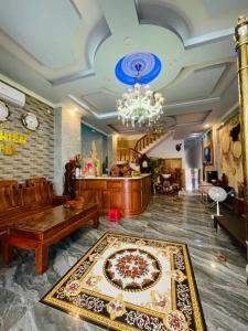 a living room with a chandelier and a rug at Khách Sạn An Nhiên in Bến Cát +8 photos