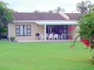 a small house with a patio and a lawn at Sole's Leap in Scottburgh