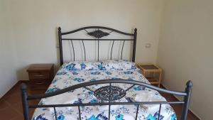 a bedroom with a bed with a blue and white comforter at Nuovo Sun Golem in Golem