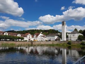 a group of white buildings next to a body of water at Hotel Garni Fuhrhop in Bad Karlshafen