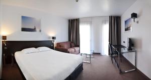 a hotel room with a large bed and a couch at Westotel Life Appart'hotels Pornic - Résidence 4 etoiles in Pornic