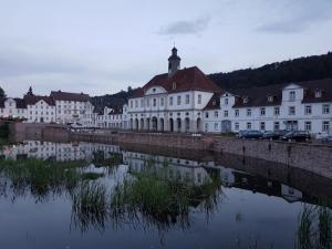 a row of white buildings next to a body of water at Hotel Garni Fuhrhop in Bad Karlshafen