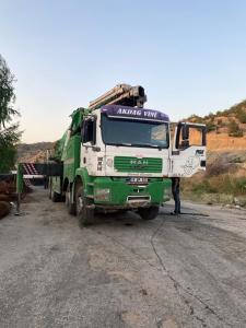 a green and white truck parked on a dirt road at Manolya apart in Zaqatala