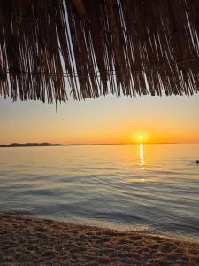 a sunset from a straw hut on the beach at Apartman Miki Borik in Zadar