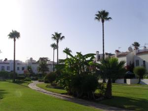 una pasarela frente a un edificio con palmeras en Casa de la Playa, en San Luis de Sabinillas