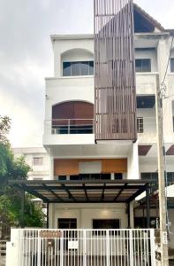 ein weißes Gebäude mit einem Balkon mit einem Zaun in der Unterkunft Impact Arena & DMK - 4BR 12pax Home 55" Smart TV in Ban Bang Talat