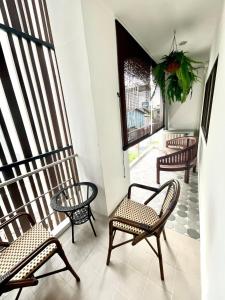 einen Balkon mit Stühlen, einem Tisch und einem Fenster in der Unterkunft Impact Arena & DMK - 4BR 12pax Home 55" Smart TV in Ban Bang Talat