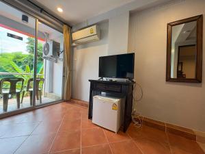 a living room with a television and a small refrigerator at LAY TONG BEACH HOTEL Patong in Patong Beach