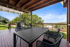 a wooden deck with a black table and chairs at Havenwood Chalet 2 Bedrooms in Ravensbourne