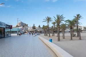 eine Straße mit Palmen am Strand in der Unterkunft Apartamento PAX4 piscina playa JAVEA in Platja de l'Arenal