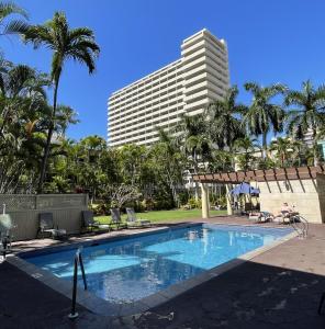 a hotel with a swimming pool and a tall building at Refreshing Royal Garden Studio condo in Honolulu