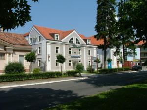 duży biały budynek z czerwonymi dachami na ulicy w obiekcie Hotel Kralj Tomislav w mieście Nova Gradiška