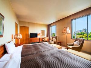 a hotel room with a large bed and windows at Hotel Concorde Hamamatsu in Hamamatsu