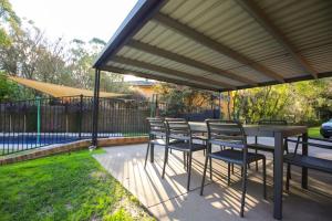 un patio con tavolo e sedie sotto un padiglione di Platypus Bend a Bright