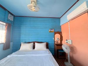 a blue room with a bed and a fan at Namknong view in Don Det +16 photos
