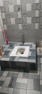 a bathroom with a toilet in a tiled floor at Shiv kripa guest house in Sehore