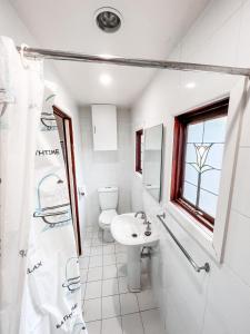 a white bathroom with a sink and a toilet at Central Castlemaine studio on steam train line in Castlemaine