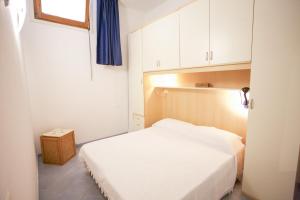 ポルトフェッラーイオにあるAppartamento Piazza Il Ficoのベッドルーム(白いベッド1台、白いキャビネット付)