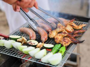 a person cooking meat and vegetables on a grill at Le GRAND BLEU - Vacation STAY 31506v in Akaoki