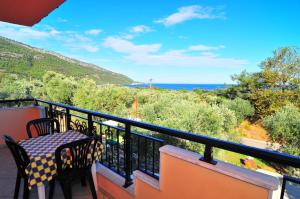 ein Balkon mit Tisch und Meerblick in der Unterkunft Studios Betty in Kinira
