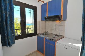 eine Küche mit Spüle und Fenster in der Unterkunft Studios Betty in Kinira