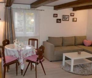 a living room with a table and a couch at Gite du Marché d'Elsa in Kilstett